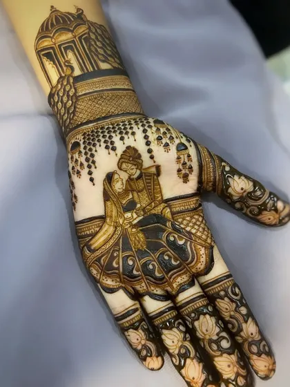 The finished couple portrait, nestled in the palm and surrounded by delicate lotus patterns on the fingers.