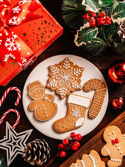 A plate of classic gingerbread cookies, iced with beautiful snowflake, snowman, and stocking designs. These are a timeless Christmas treat, perfect for enjoying with a cup of hot cocoa.