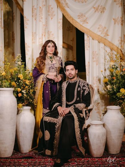 A royal portrait of the couple. The backdrop of printed drapes, earthen pots, and florals created a rich and textured setting for their Mehfil night.