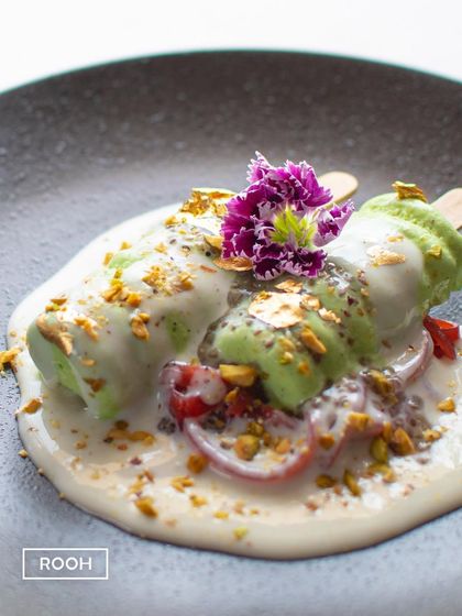 A close-up of the Chia and Kiwi Kulfi Falooda, showing the texture of the kulfi and the vibrant strawberry jelly noodles beneath.