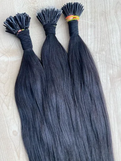 Three bundles of our premium black I-Tip extensions, showcasing their silky, straight texture.