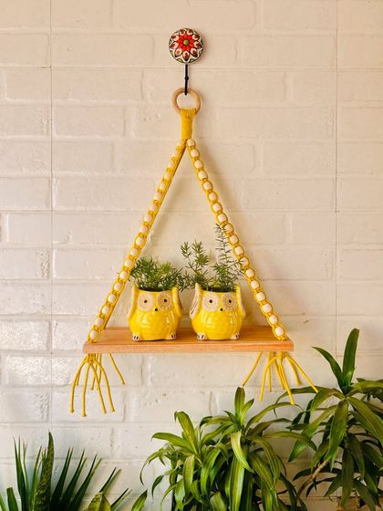 A single macrame and beads wall shelf in mustard yellow, paired with our classic ceramic owl planters. This setup is ideal for an entrance area, balcony, or any open space you want to brighten up.