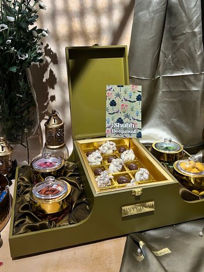 An olive green two-tiered box for Diwali. The unique shape and color make it a modern and stylish choice for festive gifting.