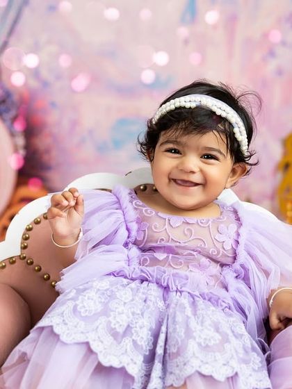 A fairytale first birthday for a little princess. This 'Once Upon a Time' theme features a dreamy pastel backdrop, a miniature throne, and a beautiful lavender dress, all provided by me.