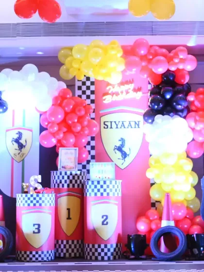 The main stage for our Ferrari-themed party. The setup includes a custom backdrop with the iconic logo, checkered flag details, and podiums for a true winner's circle feel.