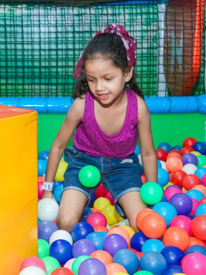 A girl having a wonderful time in our multi-colored ball pit. It's a fantastic sensory experience for toddlers.