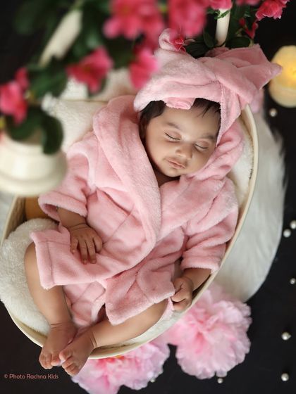 An overhead shot of the newborn in the pink robe, highlighting their peaceful expression and the cozy setup.
