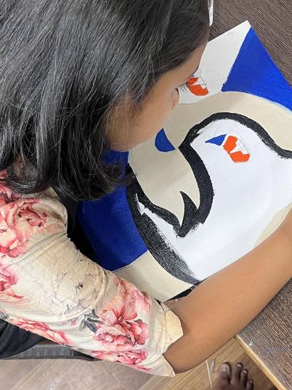 A close-up of a student carefully outlining her cat painting. This step teaches brush control and precision, which are fundamental skills for any budding artist.