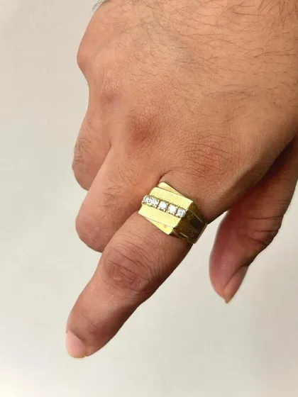 This ring demonstrates a modern approach to men's jewellery. Crafted in solid gold, it features a clean channel setting with a row of diamonds, offering a sleek and sophisticated look on the hand.
