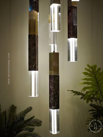 A collection of our pillar pendants, which combine sections of solid marble, fluted metal, and clear crystal. These substantial, high-quality fixtures can be hung individually or in clusters to create a dramatic effect in stairwells or entryways.