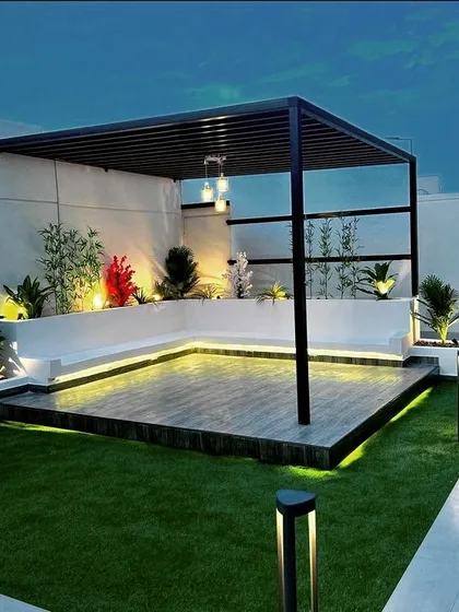 This modern rooftop terrace is transformed into a chic lounge with a sleek black metal pergola. We integrated built-in seating, a raised wooden deck, and subtle LED strip lighting to create a sophisticated ambiance perfect for evening gatherings.