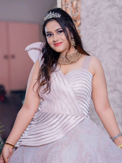 A beautiful model wearing a shimmering, structured evening gown with a tiara. This rental is perfect for a reception or engagement party.