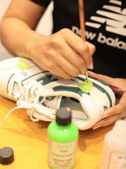 Here you can see the fine detail work involved in hand-painting sneakers. I use specialized paints and fine-tipped brushes to add vibrant colors and crisp lines directly onto the shoe, creating a durable piece of wearable art.