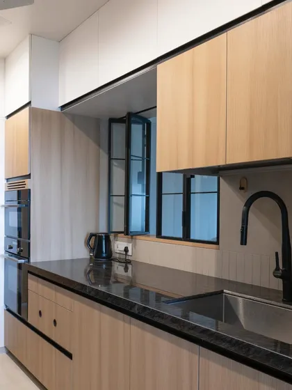 The bi-fold window in this compact kitchen is a clever addition, bringing in light and creating a connection to the rest of the home, which helps the small space feel larger.