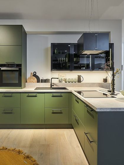 A vibrant green kitchen with an L-shaped island, showcasing a bold yet livable color choice for those who want their kitchen to be a focal point.