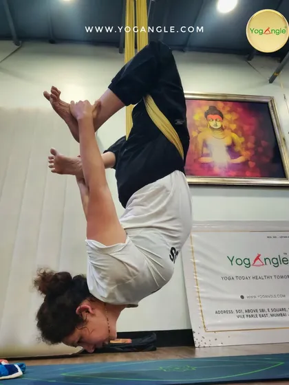 For more experienced students, we explore dynamic and challenging inversions. This pose requires significant core strength and flexibility, demonstrating the progressive nature of our aerial yoga practice.