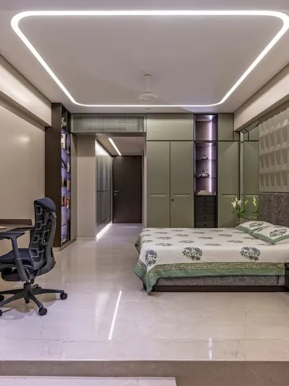 This bedroom features a multifunctional layout with an integrated desk and ample storage. The cove lighting in the ceiling adds a soft, ambient glow, making the space feel larger and more inviting.