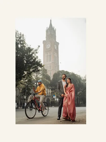 A classic portrait with the Rajabai Clock Tower in the background. The morning haze adds a soft, romantic atmosphere to this iconic Mumbai scene.