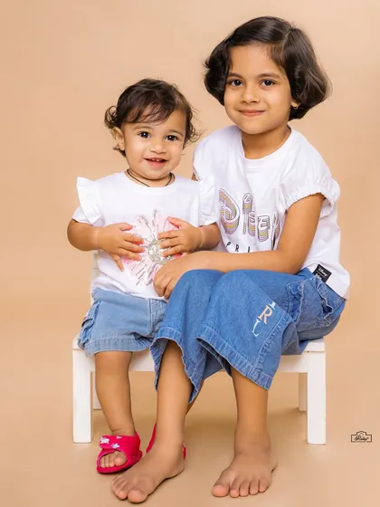 A classic portrait of two sisters sitting together. We aim to capture the unique relationship and personality of each sibling in our photoshoots.