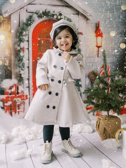 A little girl with a candy cane, full of personality. The snowy backdrop adds a touch of winter magic.