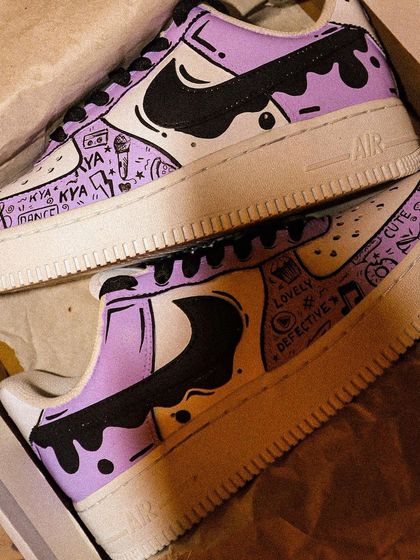 Another look at the "Lavender Haze" inspired sneakers, showing the doodle details and the dripping paint effect that wraps around the heel.
