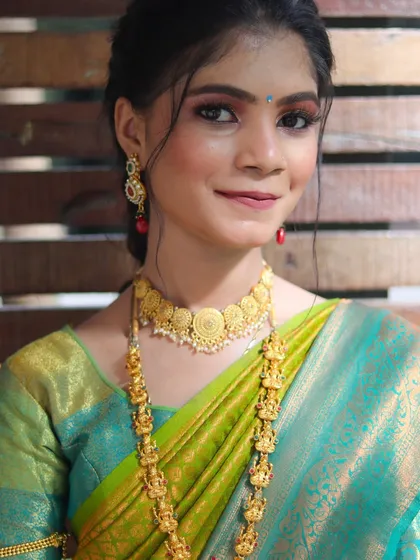 A beautiful South Indian bridal look, featuring traditional temple jewelry and a vibrant silk saree.