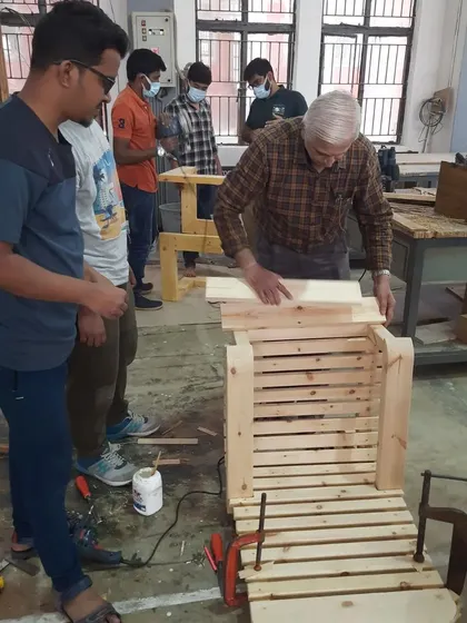 An instructor checks the alignment of a student's project during assembly, providing real-time feedback and guidance.