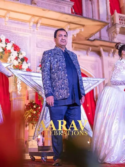 A close-up of the groom during his anniversary entry at Chomu Palace. The choreography and props are designed to make him the center of attention, celebrating his milestone in style.
