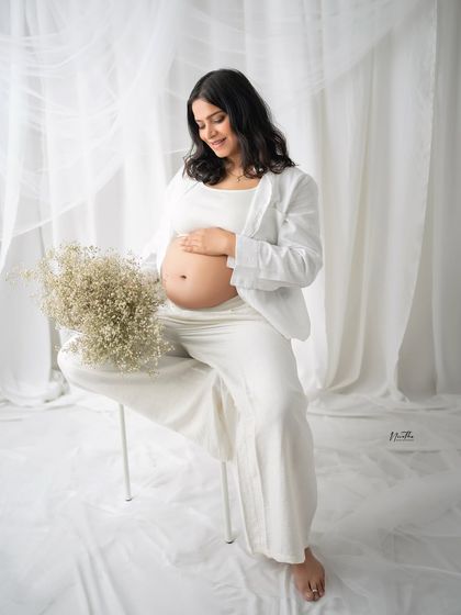 Another angle from a serene maternity session, with the mom-to-be holding a bouquet of baby's breath.