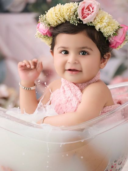 A close-up from a floral milk bath session. The flower crown and gentle splashes create a beautiful and artistic portrait.