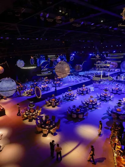 An overhead view reveals the scale of the cosmic transformation. The seating was arranged like constellations around a central dance floor, with massive, detailed planets appearing to float in the space above.