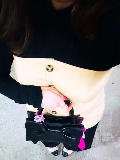 A top-down view of the layered outfit, focusing on the button details and accessories.