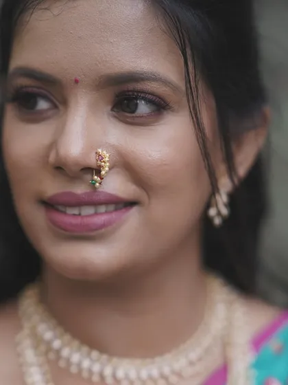 A detailed look at a soft and romantic engagement makeup style. This close-up shows the delicate eye makeup, the perfectly blended skin, and the traditional Maharashtrian 'naath' (nose ring), all coming together to create a timeless bridal look.