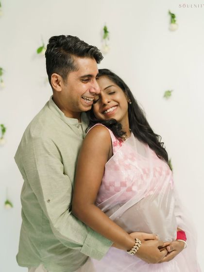 Laughter and love fill the frame in this sweet indoor portrait. The soft pink of her saree adds a delicate, traditional touch.