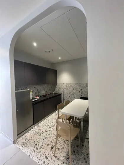The pantry and kitchenette area in our Pune office, viewed through an arched doorway. The space features modern terrazzo flooring and sleek, dark cabinetry, providing a stylish and functional area for our team to recharge.