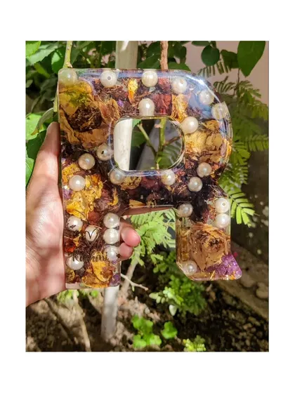A beautiful way to display your new shared initial. This 'R' monogram is filled with preserved varmala flowers and pearls, with the couple's name elegantly added. It's a perfect wedding or anniversary gift.