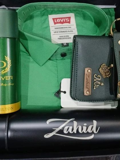 A vibrant green hamper with a Levi's shirt, a personalized wallet and keychain, and a custom flask.