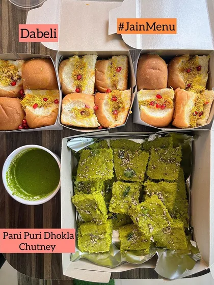 A Jain-friendly snack box with delicious Dabeli and Pani Puri Dhokla with chutney.
