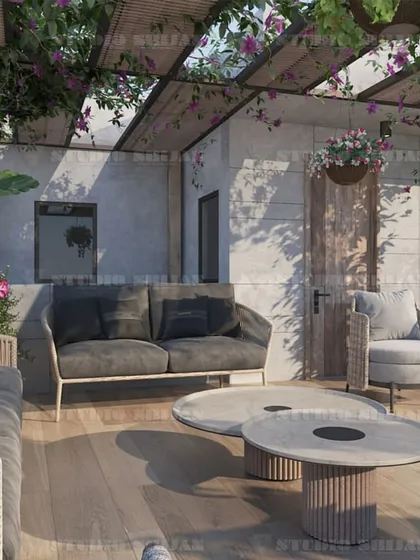 This view showcases the lush greenery and comfortable, modern outdoor furniture, designed for durability and style.