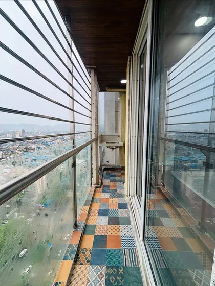 A lovely balcony with a city view, featuring colorful and patterned patchwork floor tiles. This adds a vibrant and artistic touch to the outdoor space.