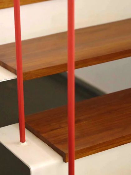 This design detail carries the red accent inside. The staircase railing features these slim red poles interspersed with black, echoing the vertical lines of the exterior facade and adding a subtle, continuous thread of color throughout the home.