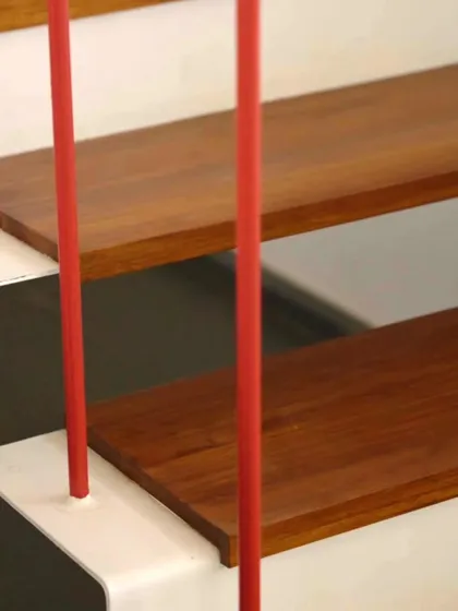 This design detail carries the red accent inside. The staircase railing features these slim red poles interspersed with black, echoing the vertical lines of the exterior facade and adding a subtle, continuous thread of color throughout the home.