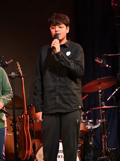 One of our teen vocal students confidently addressing the audience. Public speaking and connecting with the crowd are also part of our live performance training.