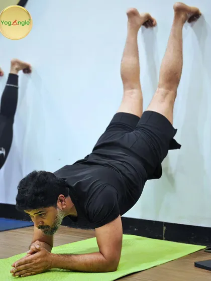 The wall is one of the best props we have. Here, a student practices a forearm stand against the wall, building the core and shoulder strength necessary for freestanding inversions in a safe, supported way.