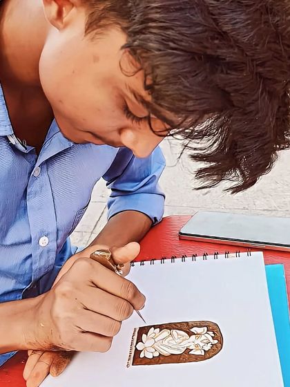Practice makes perfect. Here, one of my artists is sketching a new design on paper with a henna cone. We are always working on new patterns and perfecting our skills to bring you the best work.