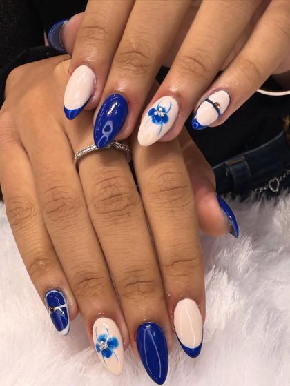 A striking combination of bold color and delicate art. This set features a vibrant royal blue polish with accent nails showcasing soft, hand-painted blue flowers on a neutral base.