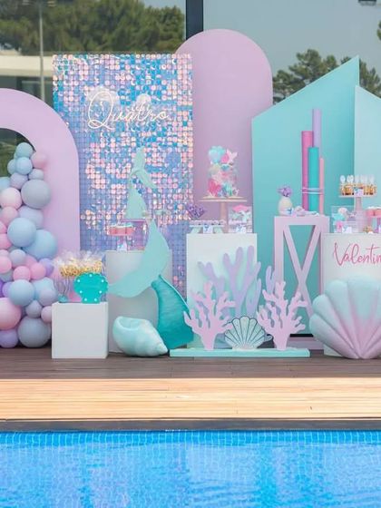 A stunning mermaid-themed party setup by the poolside. We used pastel structures, a shimmer wall, and seashell props to create an underwater kingdom, perfect for a magical celebration.