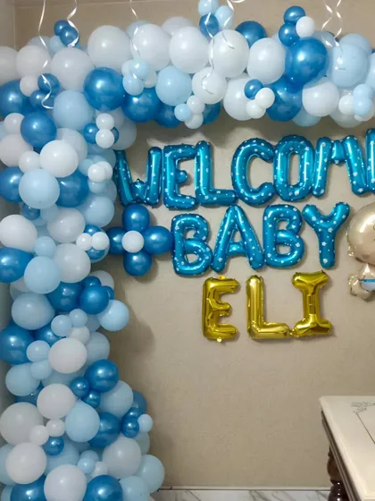 A close-up of the balloon garland and foil letters for Baby Eli's welcome party. The mix of dark blue, light blue, and white balloons creates a beautiful and gentle look for the occasion.