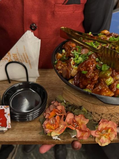Our spicy Chilli Chicken is perfect for kicking off the night with a flavorful punch. Served in a large bowl on a decorated tray, it's ready to be the star of the party.