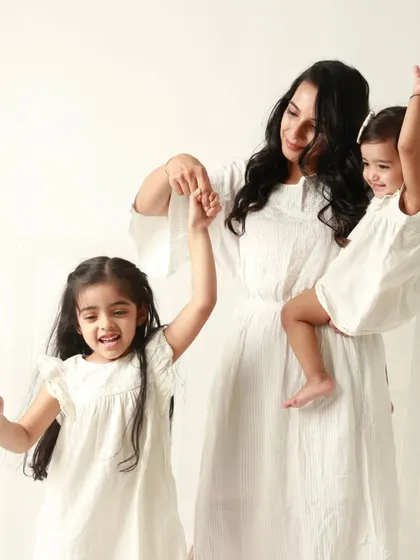 A mother's arms full of love. This joyful shot captures a candid moment of a mother dancing with her two daughters.